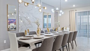 Un comedor moderno con una mesa larga dispuesta para seis personas, rodeada de sillas grises.