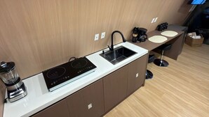 Une cuisine compacte dotée d’une cuisinière intégrée, d’un évier et d’un petit plan de travail.