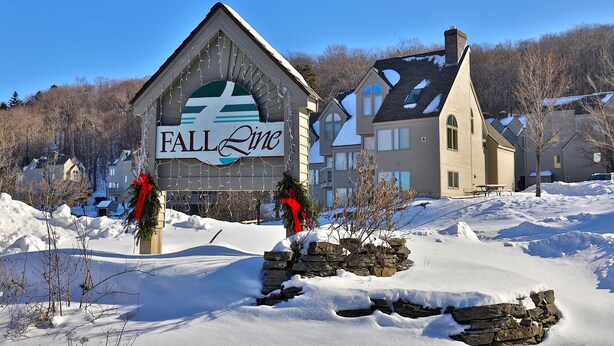 A hotel named 'FALL Line' with a stone facade and a red bow decoration. - Paging Dr. Powder Condo with Mountain Views on Shuttle Route (Killington)