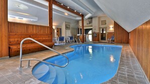 An indoor swimming pool with a wooden interior, clear ceiling, and a tiled floor. - Paging Dr. Powder Condo with Mountain Views on Shuttle Route (Killington)