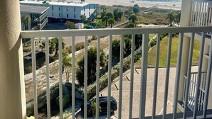 Un balcon avec vue sur une plage et l’océan.
