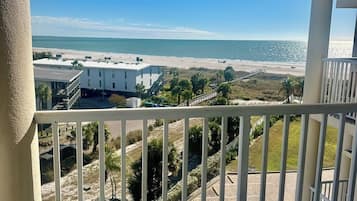 Een balkon met uitzicht op een strand en de oceaan.