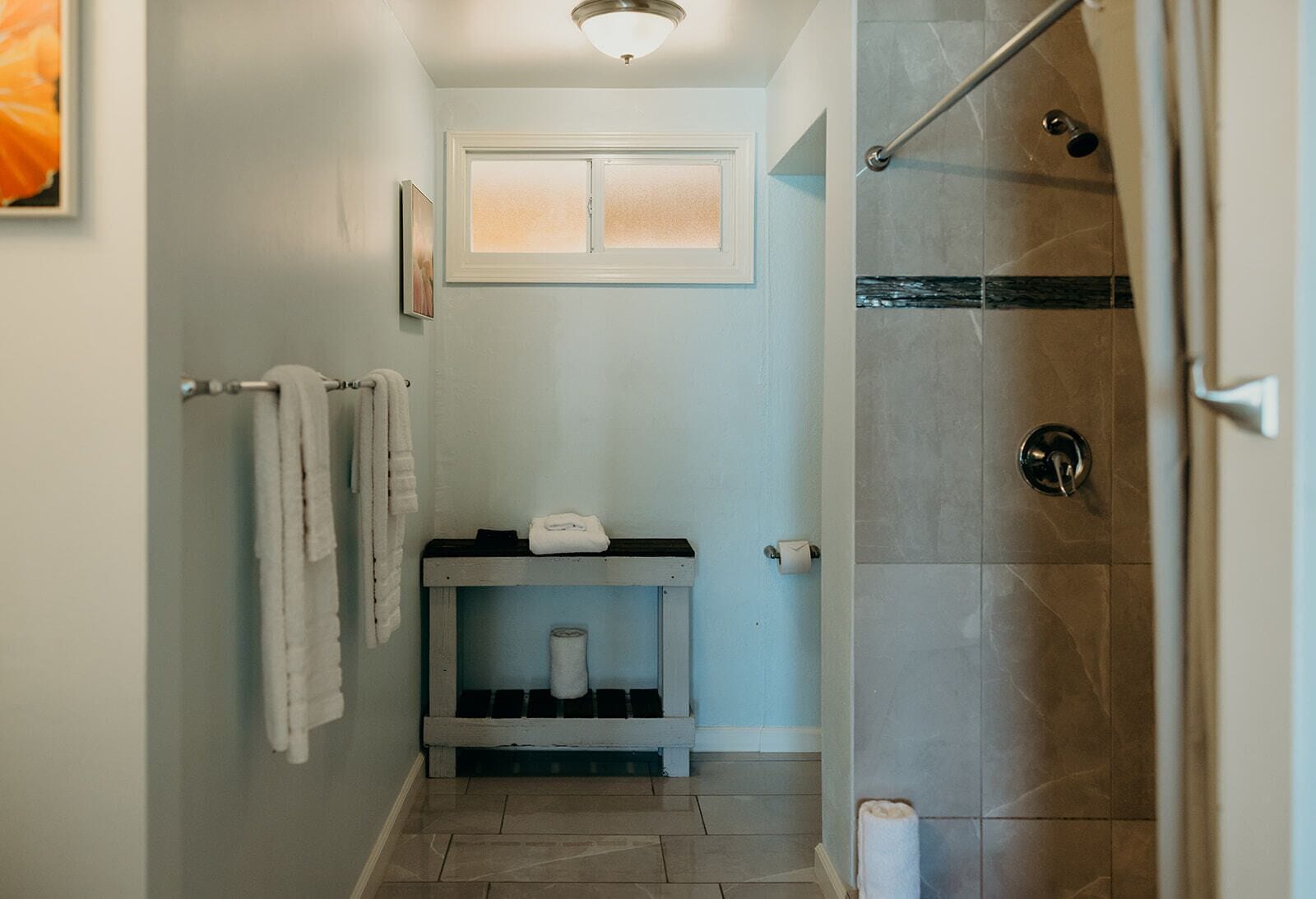 Un bany amb dutxa, un lavabo amb tovallola i un vàter.