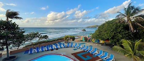 Una piscina al aire libre, sillones reclinables de piscina