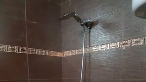 A shower with a handheld showerhead and a wall-mounted faucet. - BEDROOM DAKAR PLATEAU (Dakar)