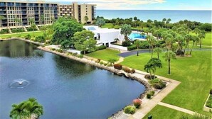 A resort with a swimming pool, a large building, and a lake. - 2/2 Condo LBK, Pool, Fitness, Tennis (Longboat Key)