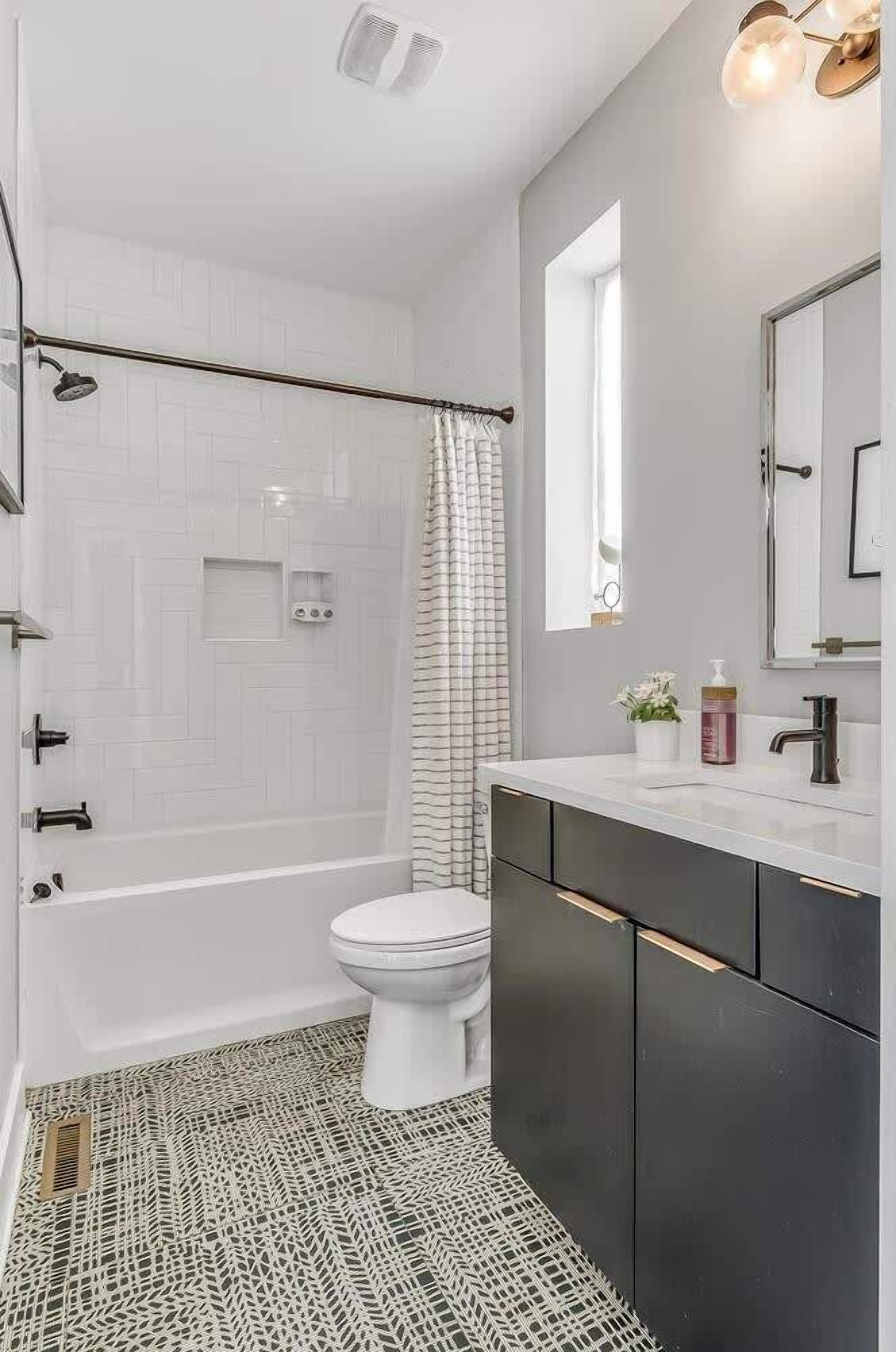 Une salle de bain moderne équipée d’une douche, de toilettes et d’un meuble-lavabo.