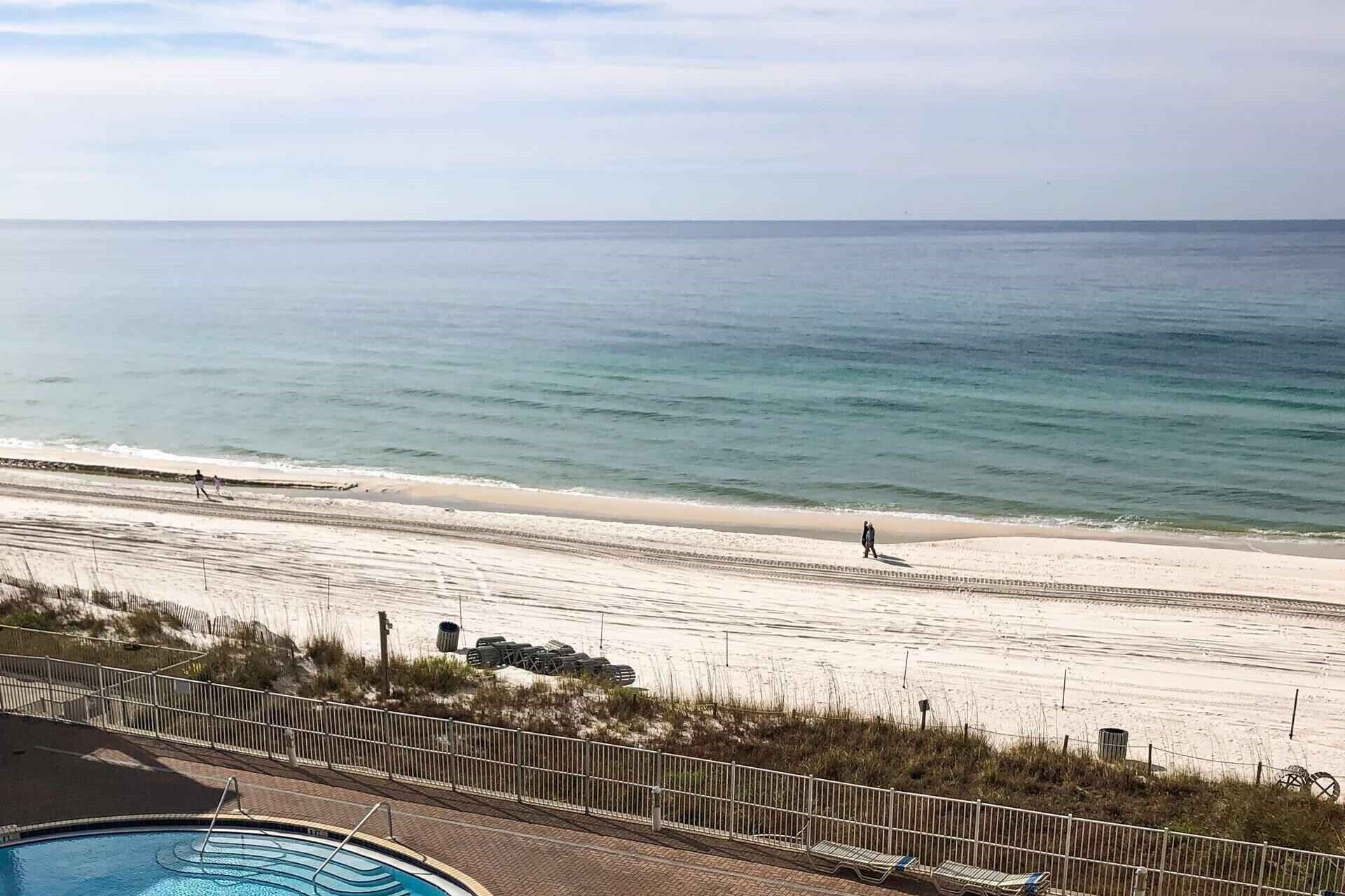 A beach view with a swimming pool and beach chairs.