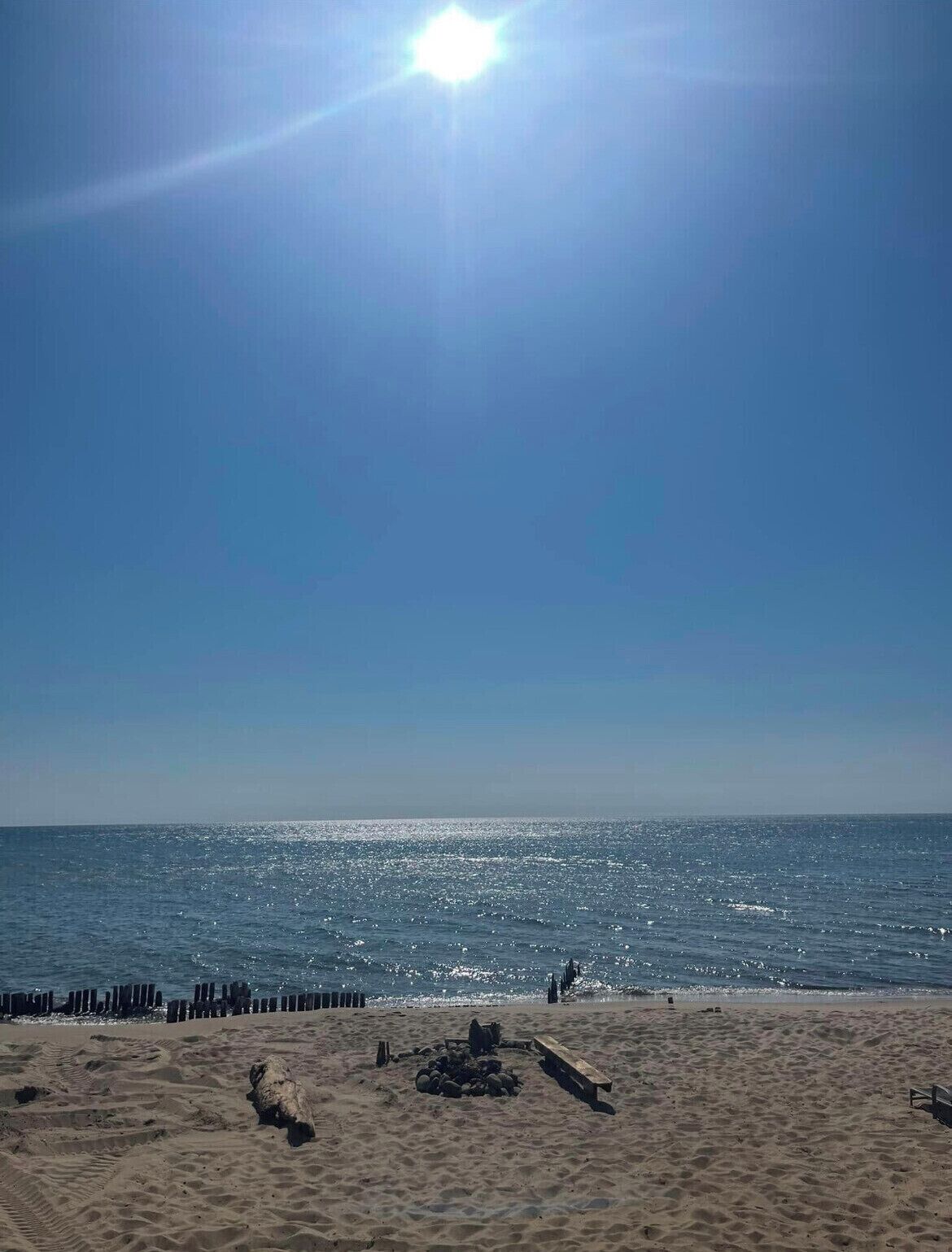A beach with a clear sky and calm sea.