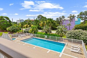 A swimming pool with a white fence, surrounded by lush greenery and a clear blue sky. - FANTASTIC 2/2.5 TOWNHOME ON 30A!! SLEEPS 7!! WALKING DISTANCE TO GULF PLACE! (Santa Rosa Beach)