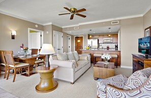 A spacious living room with a dining area, a kitchen, and a TV.