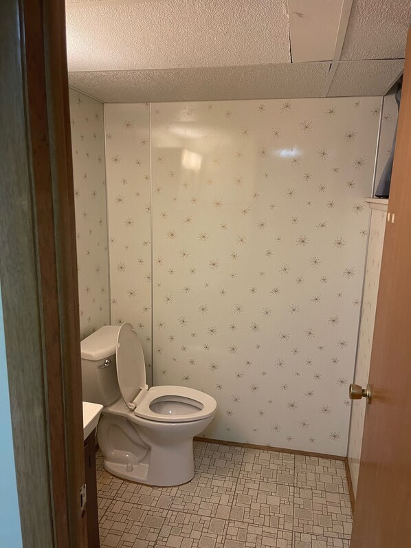 A bathroom with a toilet, a sink, and a tiled floor.