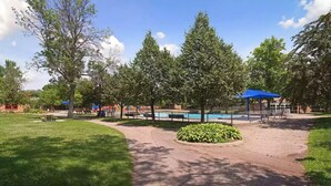 A park with a playground, a swimming pool, and picnic areas.