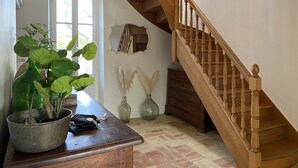 A wooden staircase with a chandelier, a potted plant, and a mirror on the wall. - Farmhouse Sleeps 11 with Shared Pool (Eymet)