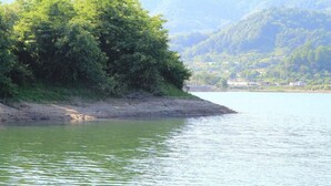 A calm river with a forested bank and a distant town. - 시골냄새가득하고 조금 불편하지만 옛날감성의 숙소 (Yecheon-gun, Gyeongsangbuk-do)