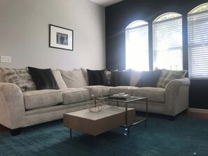 Een woonkamer met twee banken, een salontafel en een ingelijst schilderij aan de muur.
