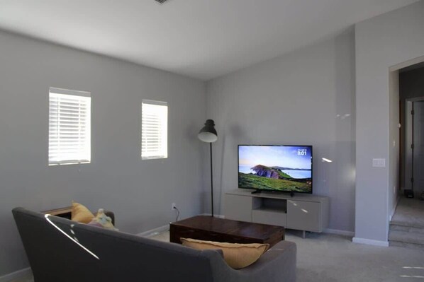 A living room with a television, a sofa, and a coffee table.