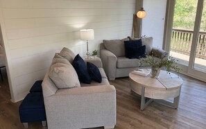 Un salon avec deux canapés, une table basse ronde et une lampe.