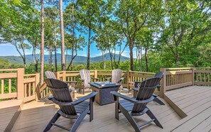 Une terrasse dotée de mobilier d’extérieur, d’un foyer et offrant une vue panoramique sur les montagnes.