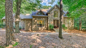 A two-story house with a stone facade, a front porch, and a driveway. - Hillside Manor - Luxury Hot Tub + Fireplace + Pool Table + & Wet Bar (Jasper)
