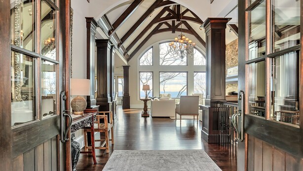 A spacious hallway with high ceilings, wooden beams, and large windows offering a view of the outdoors. - MountainView - Mountain luxury in Big Canoe! (Jasper)