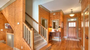 A wooden interior with a staircase, a mirror, and a door. - Paradise Retreat - Sip Cocktails by Lake Disharoon, Play Golf & Swim Year-Round (Jasper)