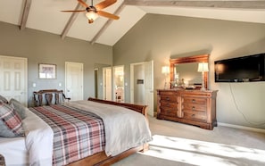 A bedroom with a bed, dresser, and TV.