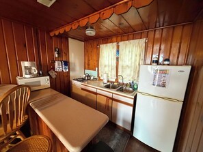 Une cuisine compacte équipée d’un four à micro-ondes, d’une cuisinière, d’un évier et d’un réfrigérateur.