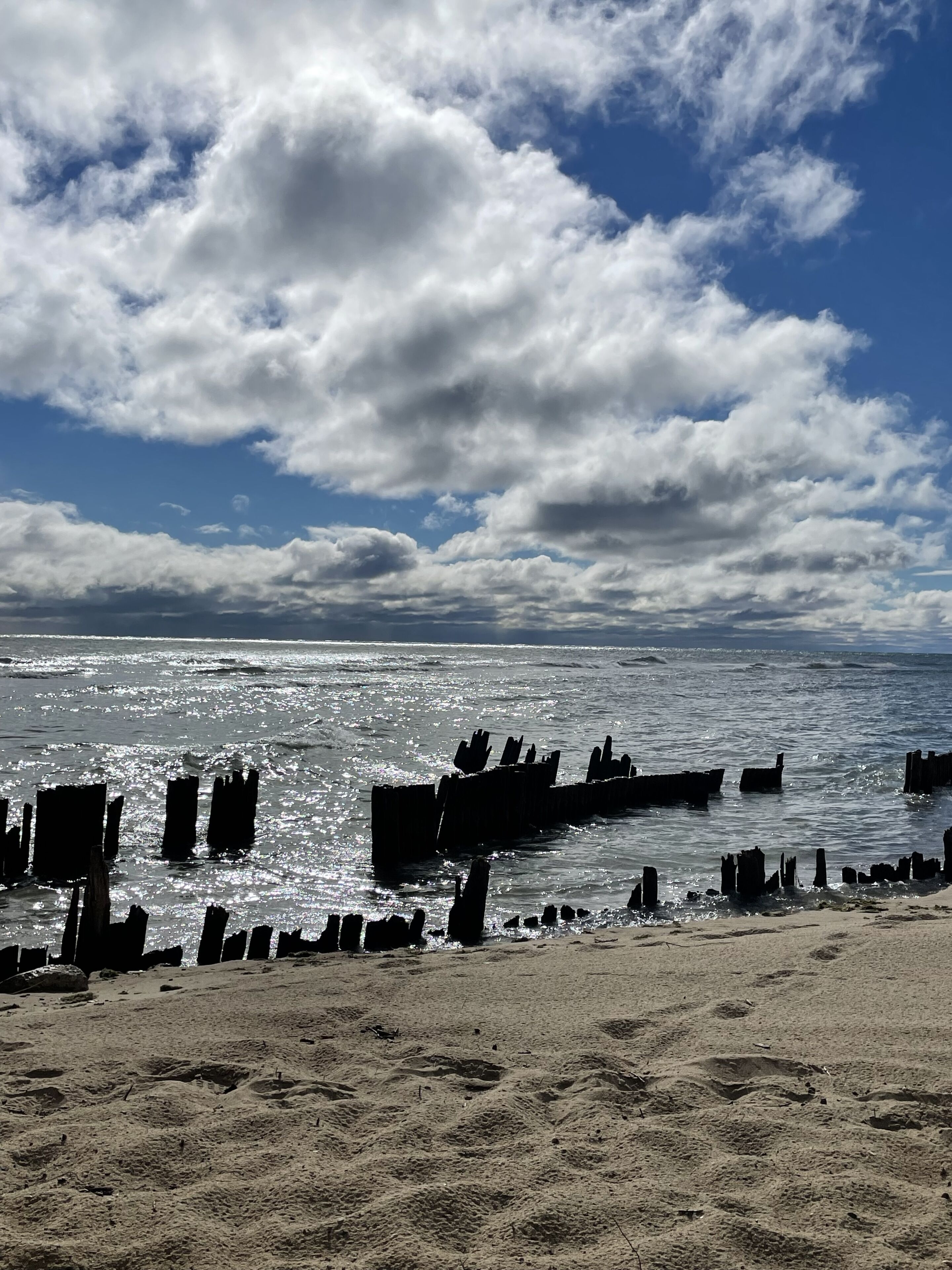 Una platja amb estructures de fusta a l'aigua i un cel serè.