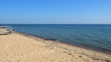 A beach with a clear sky and calm sea.