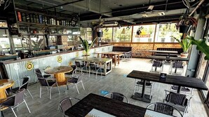 An indoor restaurant with a bar area, wooden tables, and chairs. - Casa Alegria Bed and Breakfast Antipolo (Antipolo)
