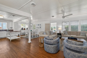 A spacious living area with a kitchen, dining table, and seating arrangements.