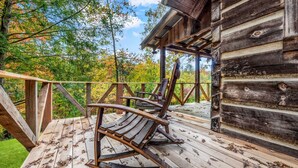 A wooden deck with rocking chairs and a view of trees. - Retreat that will have you wanting more RELAxATION (Sevierville)