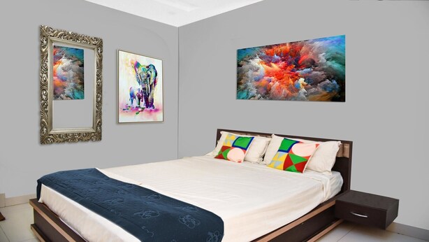A bedroom with a bed, a nightstand, and two framed artworks on the wall. - PPH Living Bhimas (Tada)