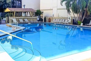 A swimming pool with lounge chairs and a covered seating area. - Peaceful Bayfront Retreat at Siesta Key's Bay Oaks (Siesta Key)