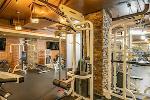 A gym with various exercise machines, a brick wall, and a ceiling with exposed pipes. - Westgate 4201 (Park City)