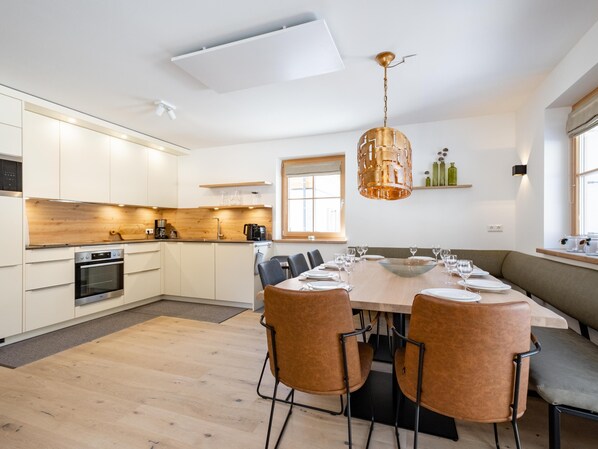 A modern kitchen with white cabinets, a wooden countertop, and a built-in oven.