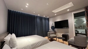 A hotel room with two beds, a desk, a chair, a TV, and a large window. - Jinhae InterCity Hotel (Changwon)