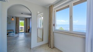 Un pasillo amplio con un gran ventanal que ofrece vistas al mar.