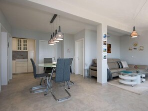 Eine moderne Wohnung mit Essbereich, Küche und Wohnzimmer.