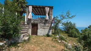 Un edificio de piedra con una puerta de madera que dice "PIRATES LOBSTER" y vista al mar.