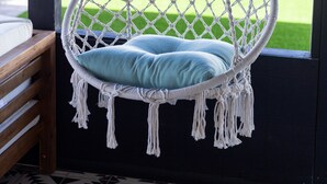 A hanging chair with a blue cushion in a room with a patterned floor. - Modern Living with an Outdoor Oasis (Scottsdale)