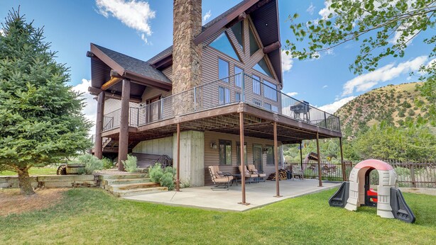 A modern house with a large deck, a chimney, and a play area. - Rustic Sterling Cabin: Walk to Palisade Lake! (Sterling)