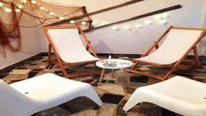 Two white lounge chairs with wooden frames, a small round table, and string lights on the floor. - Apartment Barbara (Vir)