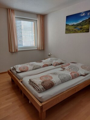 A room with a bed, a window with blinds, a lamp, and a landscape painting on the wall. - Vacation apartment Haus Annabelle Top 3 - FeWo Annabelle Top 3 (Damüls)