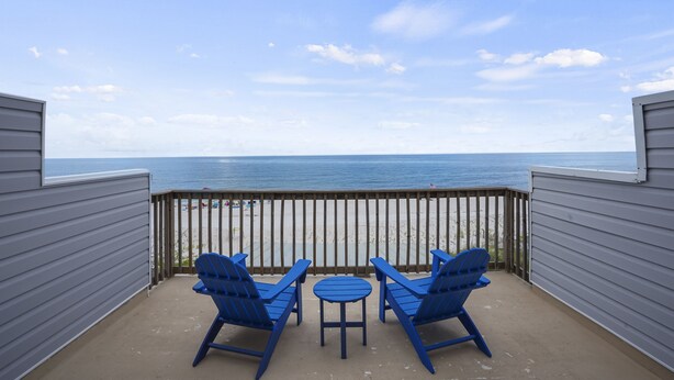 A balcony with two blue Adirondack chairs and a small table, overlooking a beach and the ocean. - Vitamin Sea - Gulf Front, Pet Friendly, Wifi, Sleeps 6 (Port St Joe)