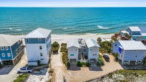 A beachfront property with multiple buildings, including a two-story house with a balcony and a smaller attached structure. - Vitamin Sea - Gulf Front, Pet Friendly, Wifi, Sleeps 6 (Port St Joe)