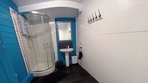 A bathroom with a glass-enclosed shower, a white sink, and a toilet.
