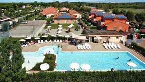Un complexe hôtelier doté d’une grande piscine, de chaises longues et offrant une vue sur le paysage environnant.