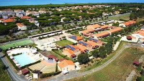 Vue aérienne d’un quartier résidentiel avec des maisons, une piscine et des panneaux solaires.